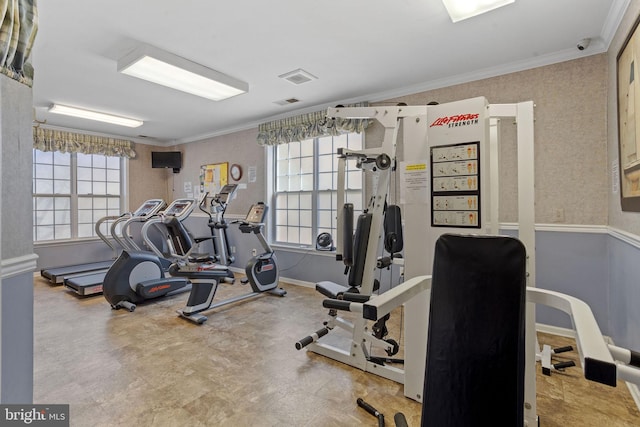 exercise room with baseboards, tile patterned floors, visible vents, and crown molding