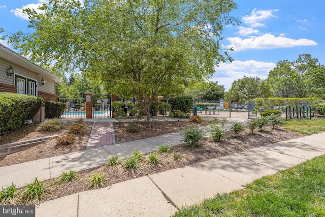 view of community featuring a pool and fence