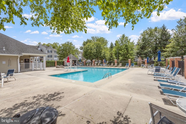 community pool featuring a patio and fence