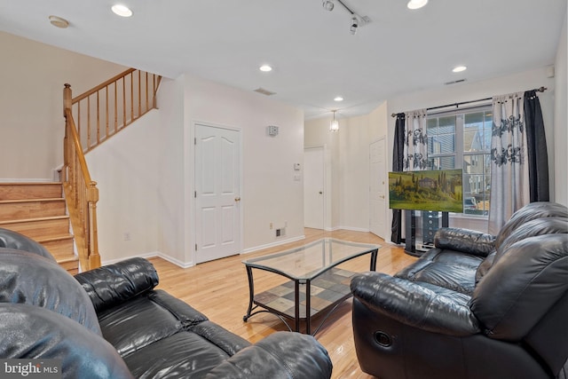 living area with light wood-style floors, recessed lighting, baseboards, and stairs