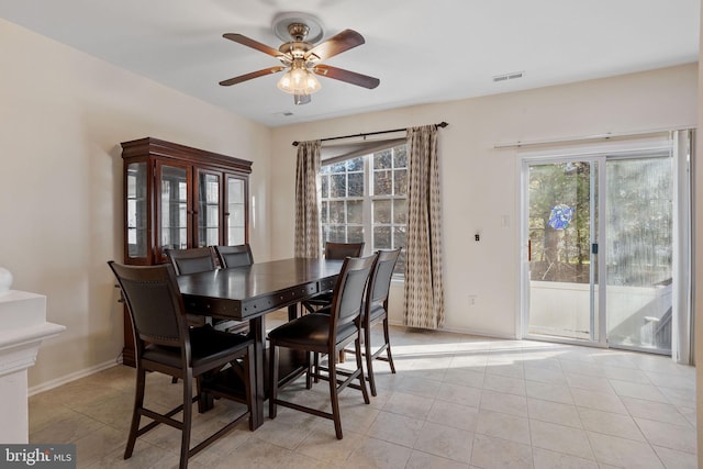 dining room with light tile patterned floors, baseboards, visible vents, and ceiling fan