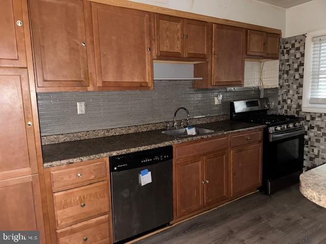 kitchen with tasteful backsplash, dishwasher, dark wood-style flooring, stainless steel gas range, and a sink