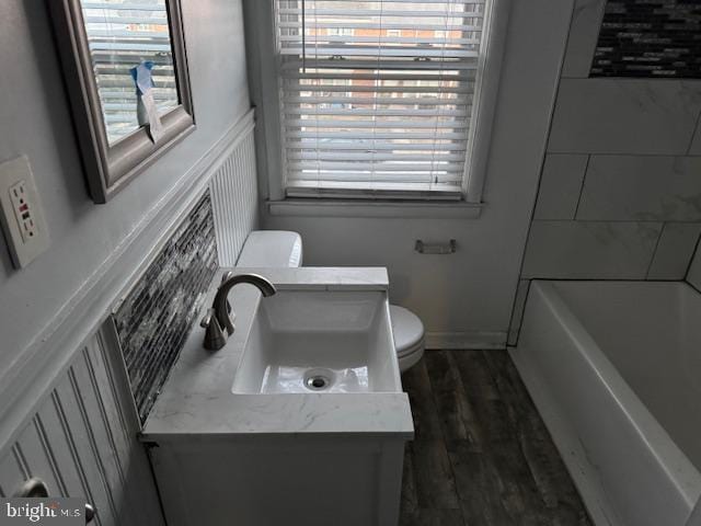 full bath with a wainscoted wall, vanity, toilet, and wood finished floors