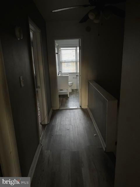 hallway featuring wood finished floors and baseboards