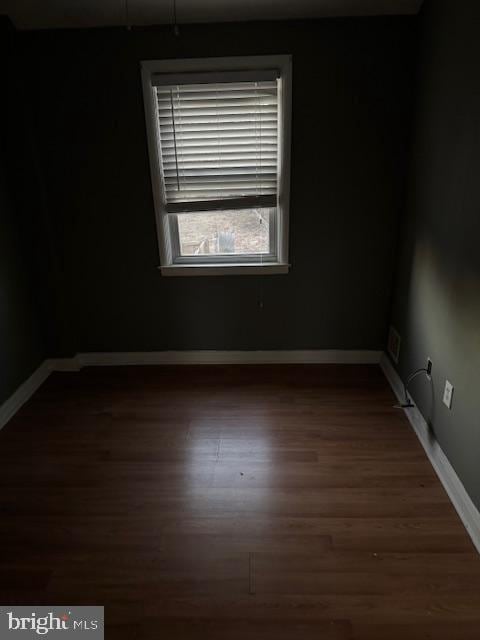 spare room with wood finished floors and baseboards