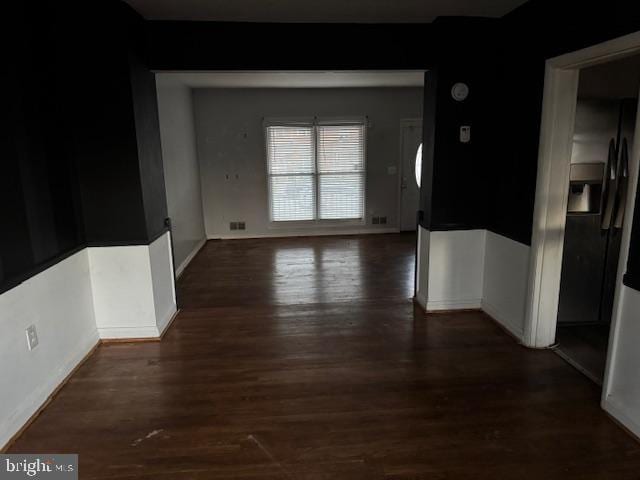 unfurnished dining area featuring baseboards and wood finished floors