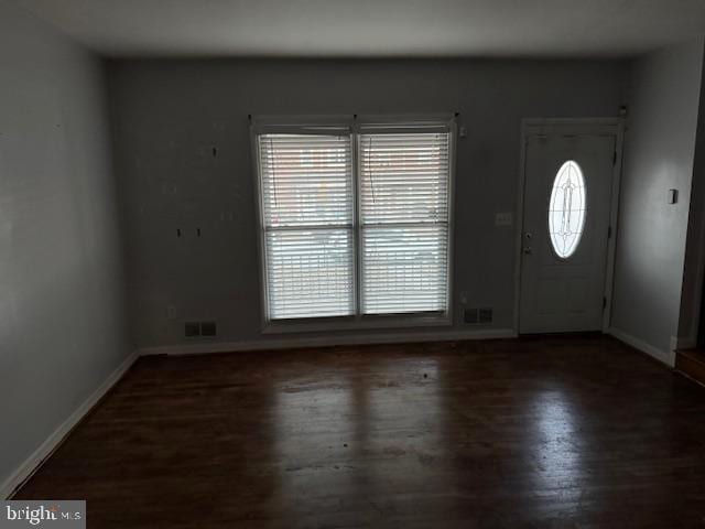 foyer featuring wood finished floors, visible vents, and baseboards