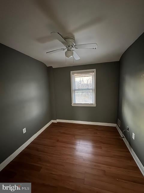 spare room with a ceiling fan, baseboards, and wood finished floors