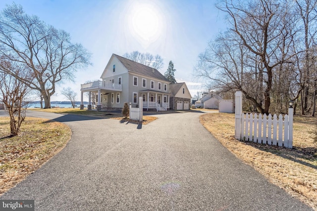 view of front of house featuring aphalt driveway, a balcony, an attached garage, and a shingled roof