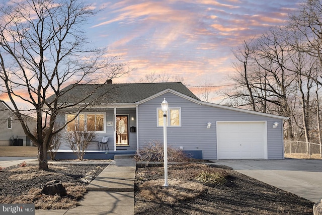 view of front facade with a garage, concrete driveway, roof with shingles, fence, and a porch