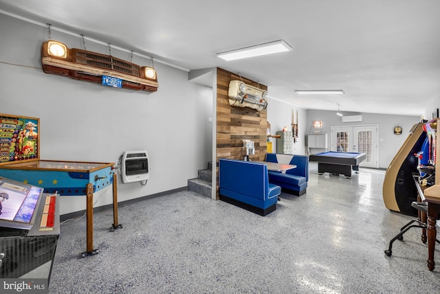 recreation room with french doors, heating unit, an AC wall unit, vaulted ceiling, and speckled floor