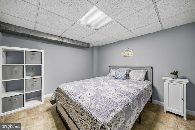 bedroom with baseboards and a drop ceiling