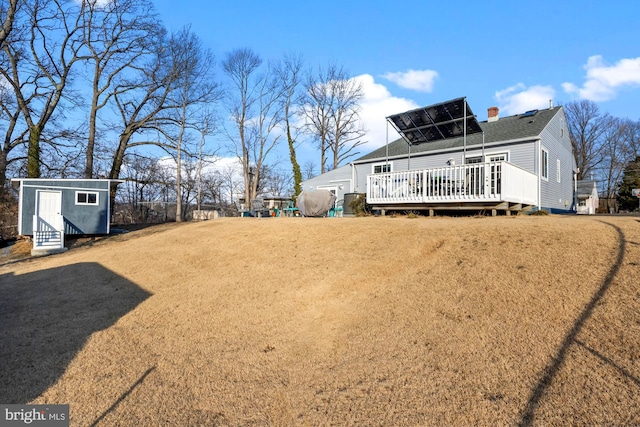 view of yard with an outbuilding, a storage unit, and a wooden deck