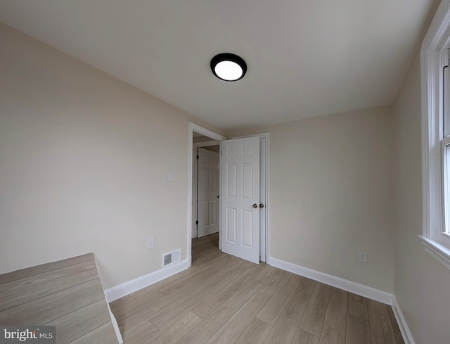 unfurnished bedroom featuring light wood finished floors, baseboards, and visible vents