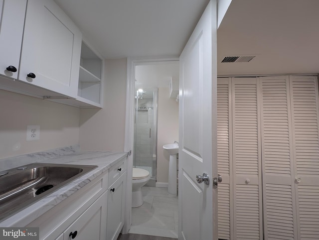 full bathroom featuring toilet, vanity, visible vents, a closet, and a stall shower