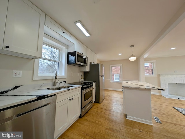 kitchen with visible vents, hanging light fixtures, appliances with stainless steel finishes, white cabinetry, and light wood-type flooring