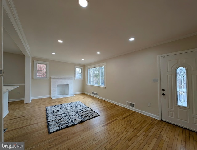 foyer featuring visible vents, a fireplace, and light wood-style flooring