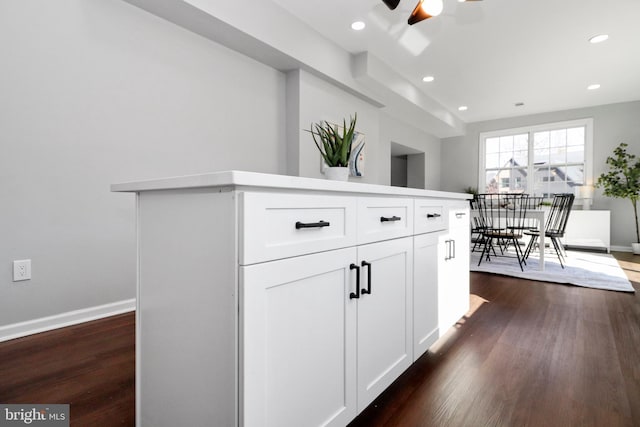 kitchen with recessed lighting, dark wood-style flooring, white cabinets, and baseboards