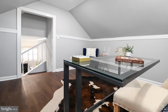 dining area featuring lofted ceiling, baseboards, and wood finished floors