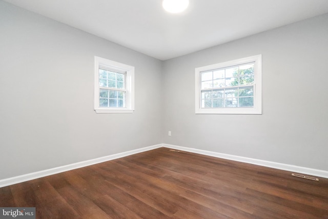 empty room featuring baseboards, visible vents, and a healthy amount of sunlight