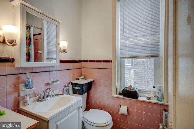 bathroom featuring toilet, a shower with curtain, tile walls, and vanity