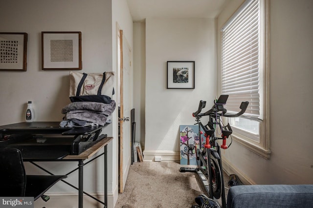 workout room featuring carpet and baseboards