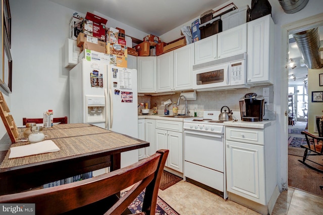 kitchen with light countertops, white appliances, a sink, and white cabinetry