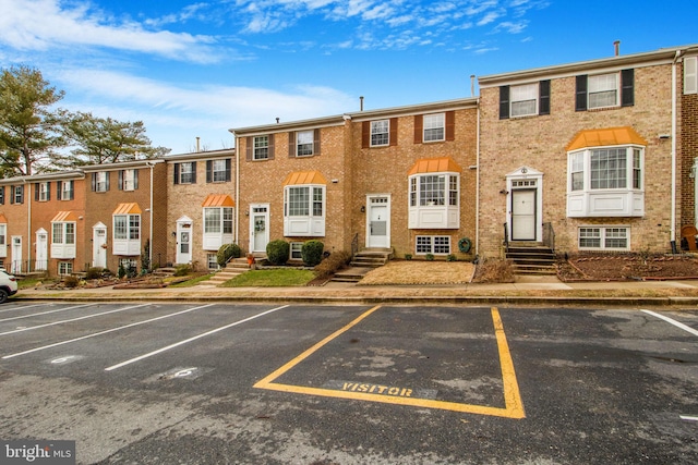 exterior space with entry steps and uncovered parking