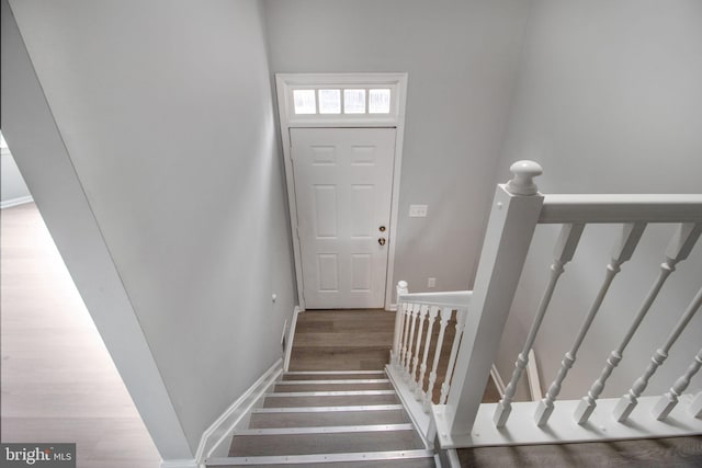 stairway featuring wood finished floors and baseboards