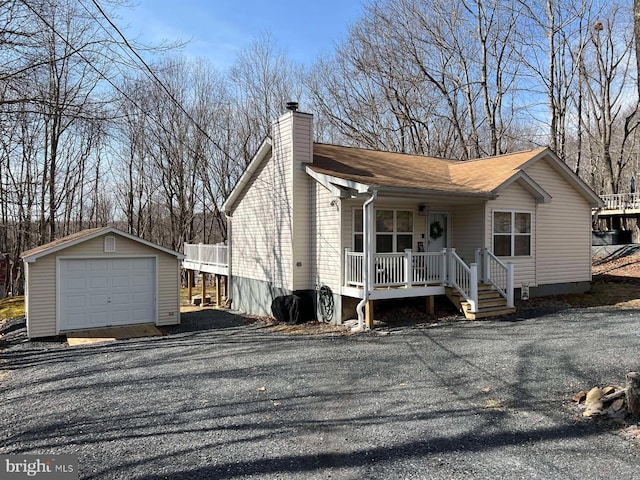 view of front facade with covered porch, a chimney, a garage, an outdoor structure, and driveway