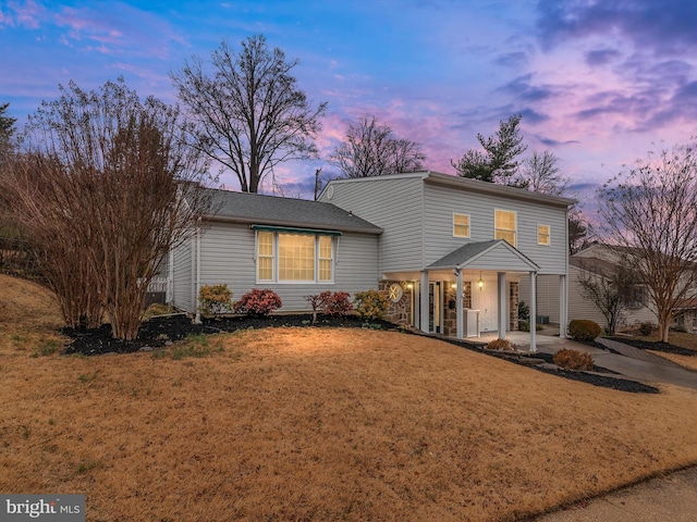 view of front of property featuring driveway and a yard