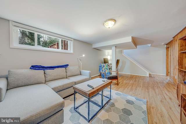 living room featuring stairway, baseboards, and wood finished floors