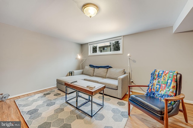 living area featuring baseboards and light wood finished floors