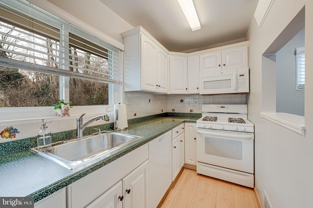 kitchen featuring light wood finished floors, visible vents, white cabinetry, a sink, and white appliances