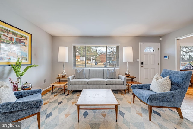 living area featuring baseboards, plenty of natural light, and light wood-style floors