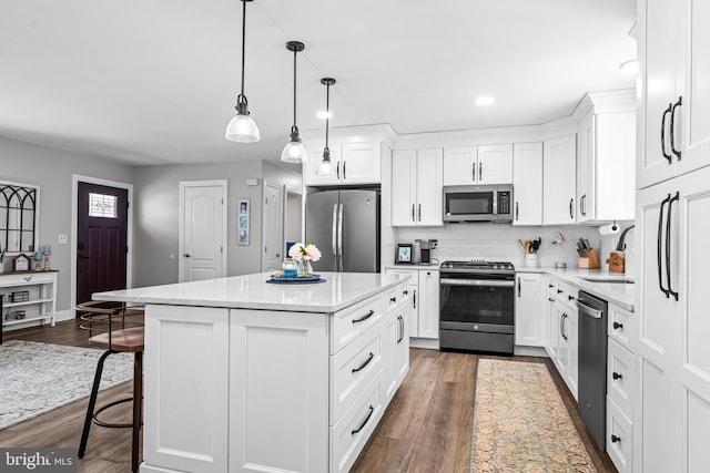 kitchen featuring stainless steel appliances, a center island, dark wood-style flooring, and a sink