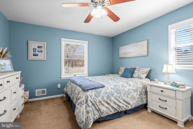 bedroom with light carpet, baseboards, visible vents, and a ceiling fan