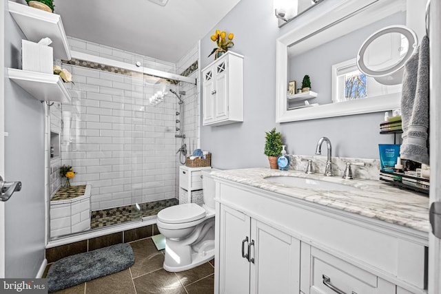 full bath featuring tiled shower, tile patterned flooring, vanity, and toilet