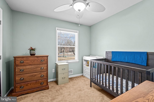 bedroom featuring carpet floors, visible vents, ceiling fan, a nursery area, and baseboards