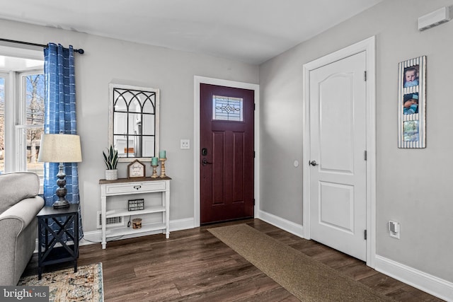 foyer with dark wood-style floors, visible vents, and baseboards