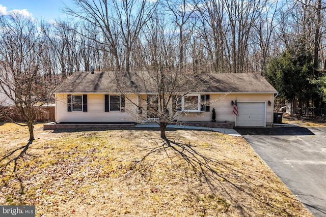 single story home featuring an attached garage, driveway, and fence