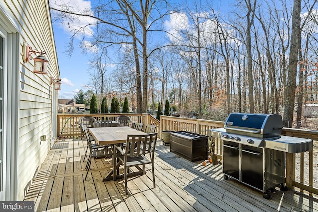 wooden deck with grilling area and outdoor dining space