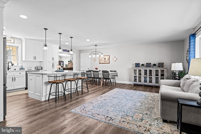 living room featuring dark wood-style floors, recessed lighting, a chandelier, and baseboards