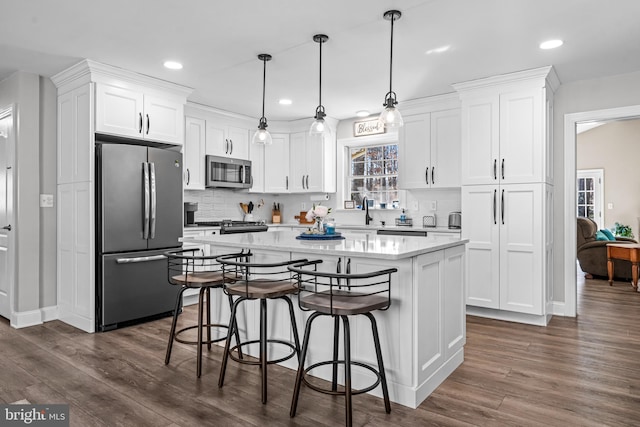 kitchen with white cabinetry, a kitchen island, appliances with stainless steel finishes, and a sink