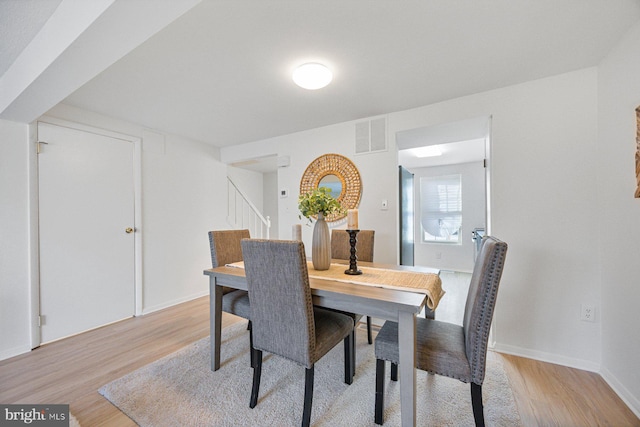 dining space featuring baseboards, visible vents, and light wood-style floors