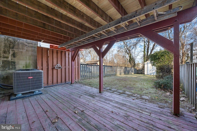 deck with a fenced backyard, an outdoor structure, a storage shed, and central AC unit