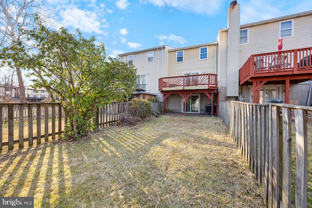 rear view of property with a lawn and a fenced backyard