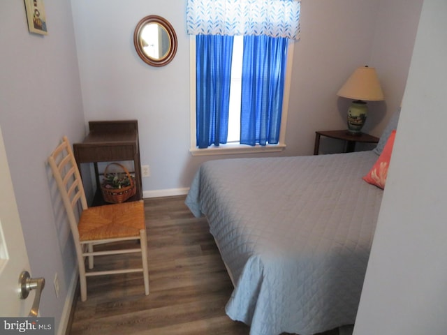 bedroom featuring wood finished floors and baseboards