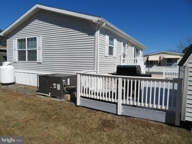 view of home's exterior featuring a wooden deck and central AC unit