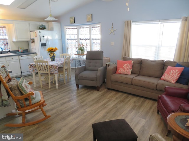 living area featuring vaulted ceiling and light wood finished floors